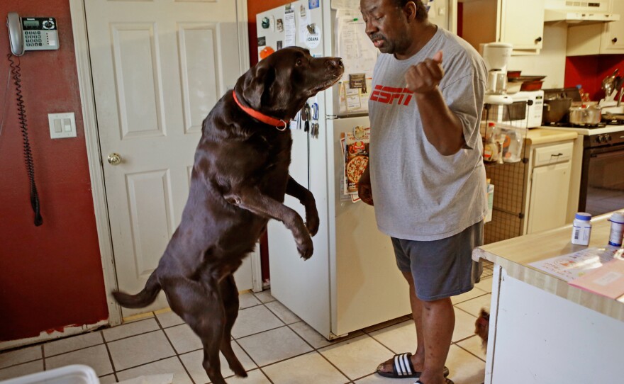 Mike Jackson and his dog Coco at home in Oklahoma City. He says of his medical costs: "If anything goes wrong, I'm one step away from disaster."