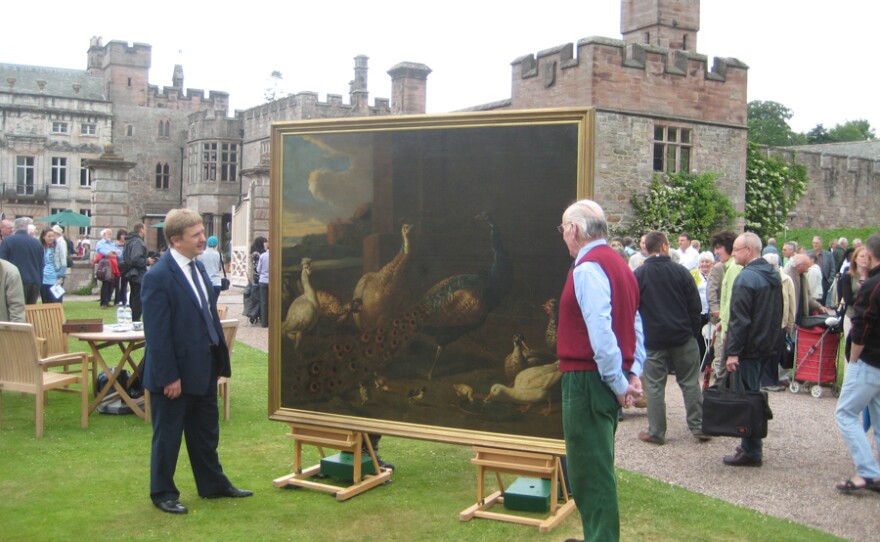 Grant Ford examines a large painting of farmyard birds.