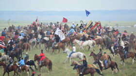 Horse mounted riders circle atop a hill at the Battle of Little Bighorn National Monument, near Last Stand Hill, on June 25.