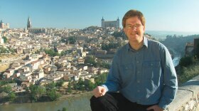 Rick Steves with a scenic view of Toledo, Spain in the background.