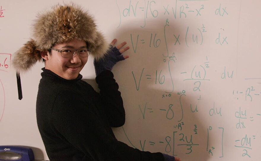 Alvan smiling in front of math problem.