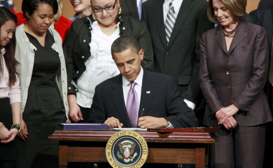 Pelosi looks on as President Barack Obama signs the health care overhaul bill in March.