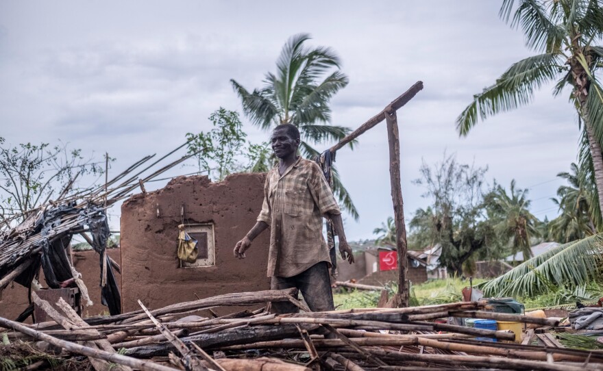 A man stands in his wrecked home in Macomia.