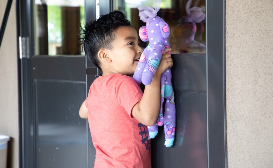 Emmanuel Zacarías, 4, plays through a window with other children at Operation HOPE in Vista on March 21, 2020.