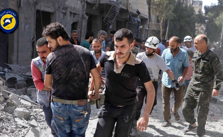 White Helmet rescue volunteers work at the site of airstrikes in the rebel-held al-Mashhad neighborhood in eastern Aleppo on Wednesday.