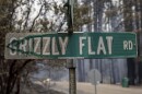 In this Tuesday, Aug. 17, 2021 file photo, a partially melted street sign stands after the Caldor Fire burned through Grizzly Flats, Calif. Last week, managers overseeing the fight against the massive wildfire scorching California's Lake Tahoe region thought they could have it contained by the start of this week.