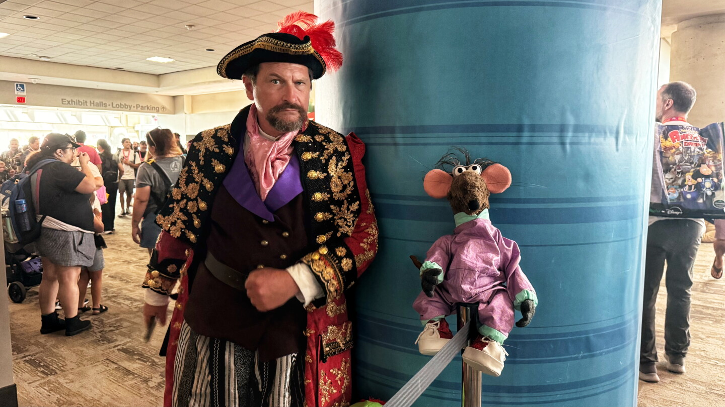 A cosplayer dressed as Long John Silver from "Muppet Treasure Island" poses alongside a puppet companion at Comic-Con on July 26, 2026.