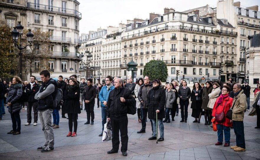 People gather to hold a minute of silence in front of the Paris city Hall, France, on Monday.