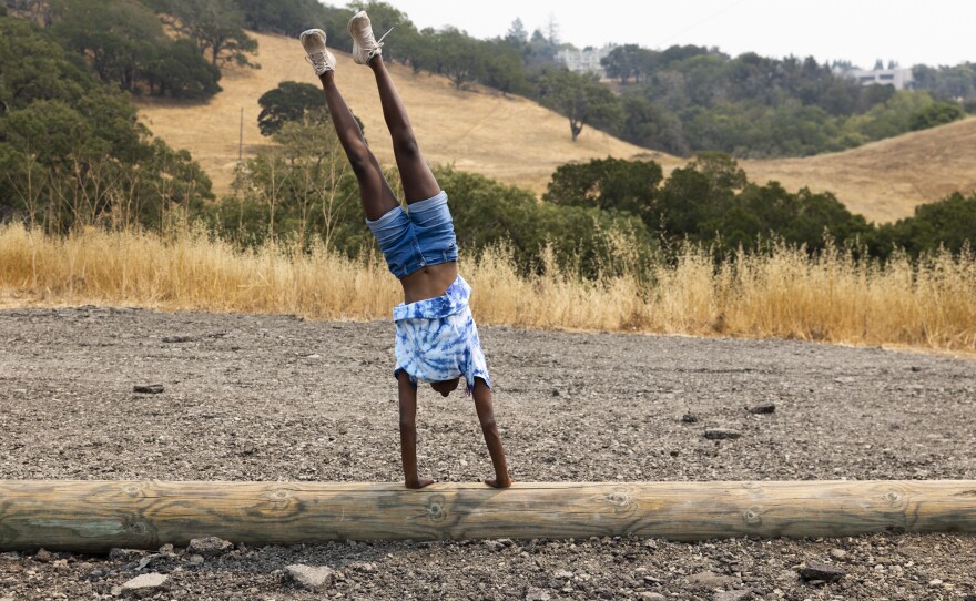 Josie, who is of Ethiopian descent, practices a handstand.