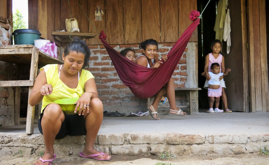 Ligda Bol, 19 years old, sits in front of her small farm. Her house, near the Brito River, is in the path of the proposed canal. Her family hasn't been told if she'll be forced to move, when a decision will be made or how she will be compensated for her farm.