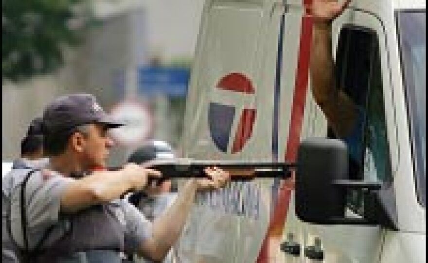 A police officer searches a van for members of a criminal gang blamed for a wave of attacks on banks, police stations and buses that all but shut down Sao Paulo in May 2006.