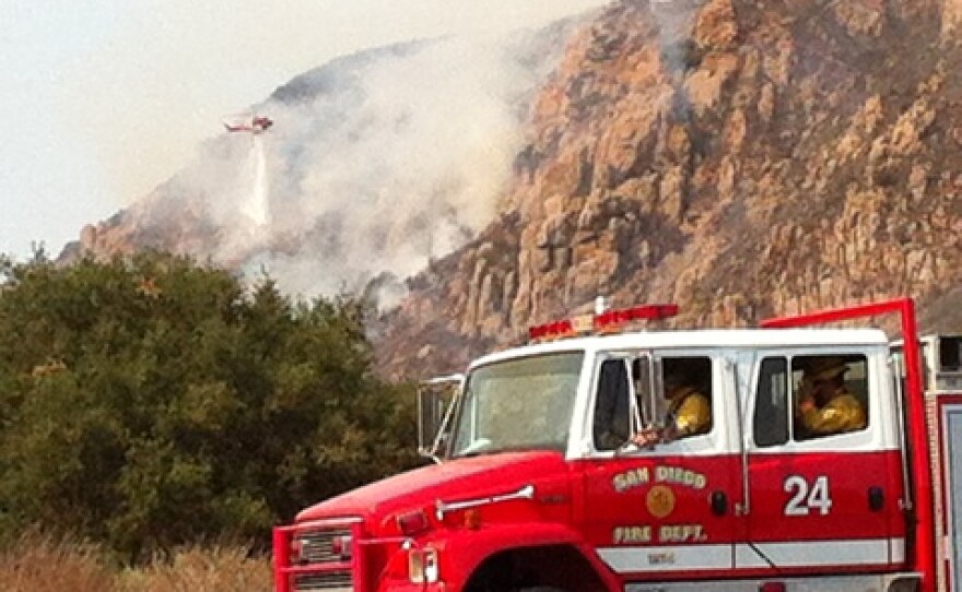 A helicopter makes water drops on a brush fire that broke out in Mission Trails Regional Park, July 13, 2014.
