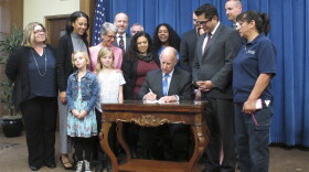 California Gov. Jerry Brown signs into law a measure increasing the amount of income Californians can receive during the state's existing six weeks of paid family leave in Sacramento, April 11, 2016. 