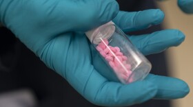 Jonathan Dumke, a senior forensic chemist with the Drug Enforcement Administration, holds a container of fentanyl pills at a DEA research laboratory on Tuesday, April 29, 2025, in Northern Virginia.