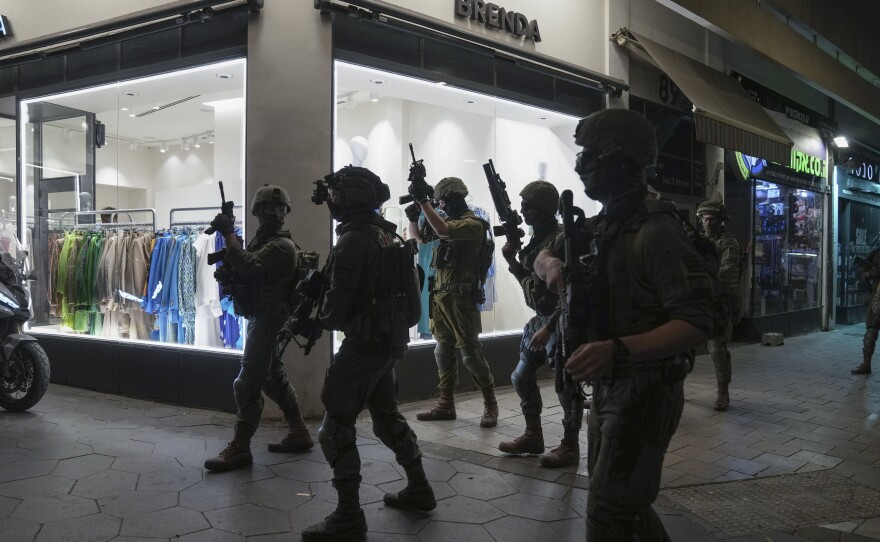 Israeli security forces search for assailants near the scene of a shooting attack in Tel Aviv, on Thursday.