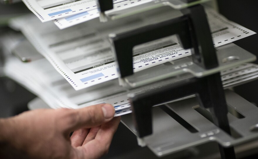 Poll workers sort out early and absentee ballots on Election Day in Kenosha, Wis. Hours after the polls closed around the country, there's still no winner in the presidential contest.