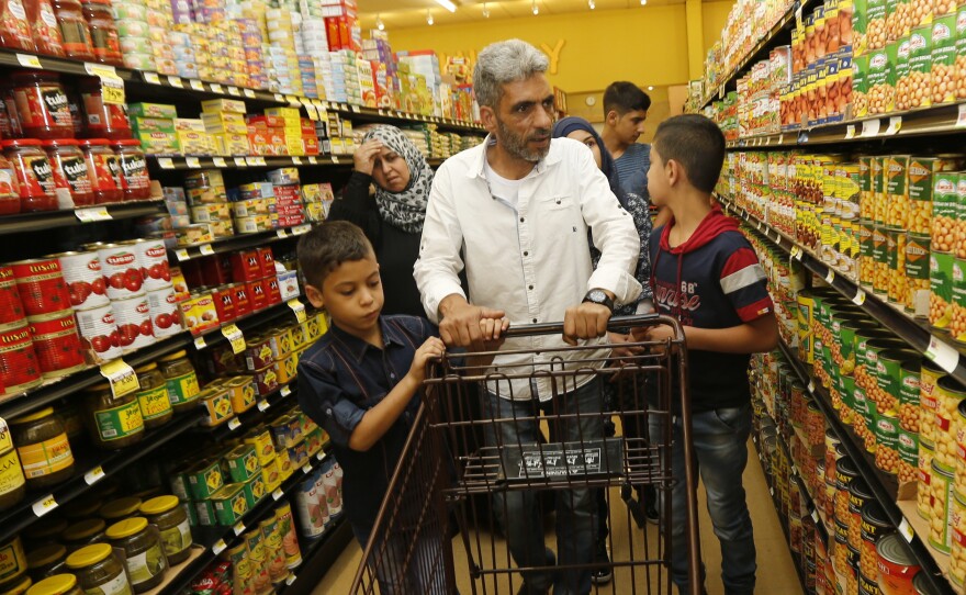 Nadim Fawzi Jouriyeh, a Syrian refugee who arrived in the United States in August with his family, pushes a shopping cart in El Cajon, Calif.