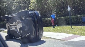 Golfer Tiger Woods stands by his overturned vehicle in Jupiter Island, Fla., on Friday, March 27, 2026.