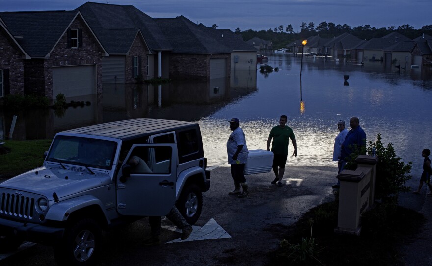 Residents evacuate with food in ice chests in Hammond, La., on Saturday.