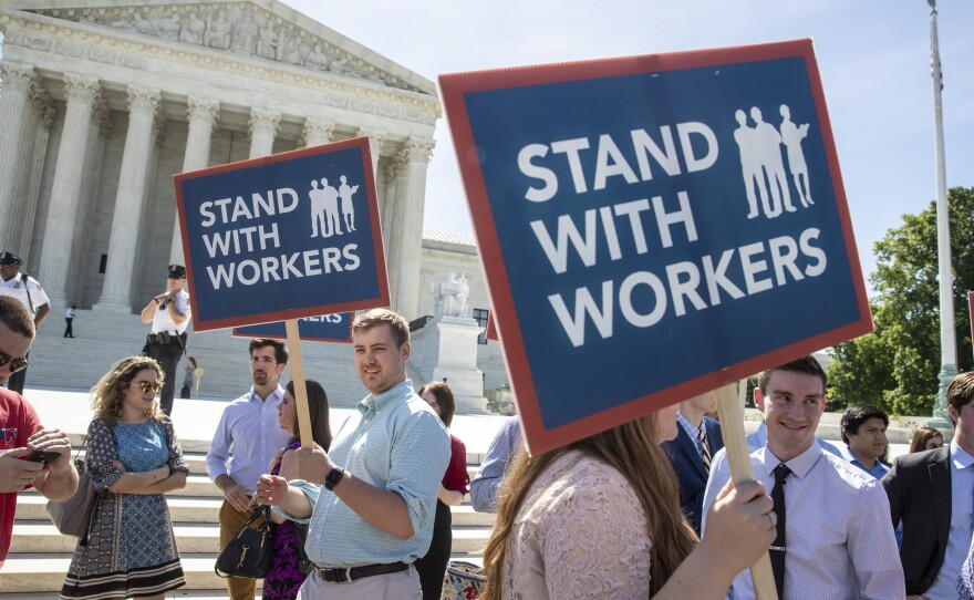 People gather at the Supreme Court awaiting a decision in an Illinois union dues case, Janus v. AFSCME, on Monday.