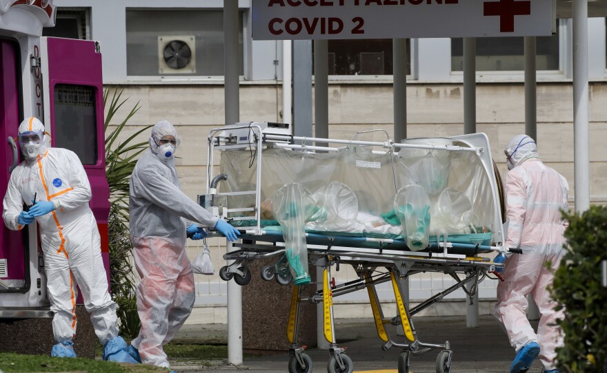 A patient in a biocontainment unit is carried on a stretcher from an ambulance at a Rome hospital in March.