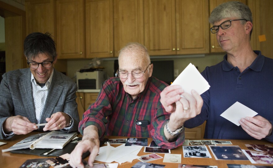 Bruce Auster (left), with his father, Stanley, and his brother, Gordon, look at family photographs at Gordon's home in Kildeer, Ill. A decades-old recording of Bruce's mother trying to convince Gordon that Santa Claus is real has brought back memories for the family.