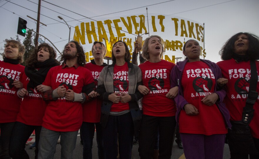 Striking McDonald's restaurant employees lock arms during nationwide "Fight for $15 Day of Disruption" protests.