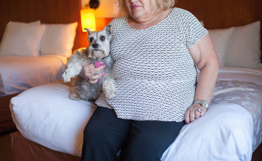 Kathy Hughes sits with her dog Gracie at the La Quinta in Norman, Okla., on Wednesday. This is their third night at the La Quinta, which is one of the few area hotels accepting people and their pets.