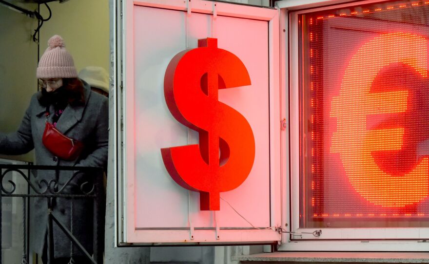 A woman leaves a currency exchange office displaying the dollar and the euro signs in Saint Petersburg, Russia, on March 2.