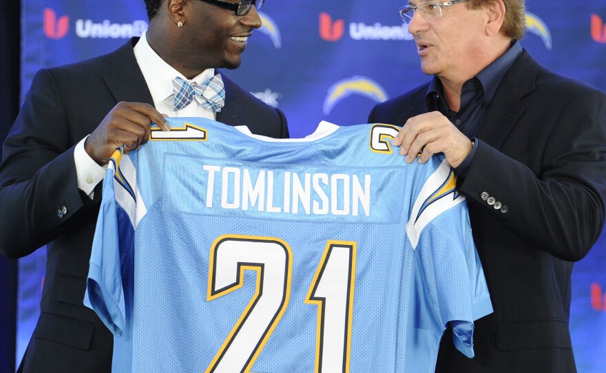 Former San Diego Chargers running back LaDainian Tomlinson, left, and Chargers president Dean Spanos hold up Tomlinson's #21 jersey at a news conference held at the San Diego Chargers facility, June 18, 2012 in San Diego. 