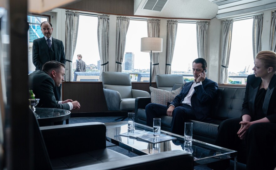 The Roy siblings huddle with the Waystar communications team to craft a statement after learning of their father's sudden death.