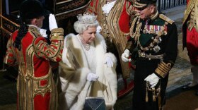Queen Elizabeth II and the Duke of Edinburgh (right, in black uniform) arrive by royal carriage at the House of Lords in London for the state opening of Parliament.