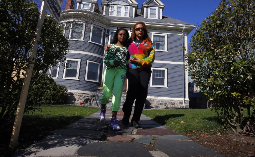 At the Richard family home in Dorchester, Mass., on Tuesday, Jacqueline Myers (right) and her 10-year-old daughter Amira were among those who came to grieve over the death of 8-year-old Martin Richard. He was killed by one of the blasts at Monday's Boston Marathon. His mother and sister were seriously injured.