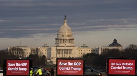 Billboard trucks parked on the National Mall near of the U.S. Capitol during the impeachment trial of former President Donald Trump in Washington, Tuesday, Feb. 9, 2021.