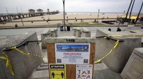 A sign gives social distance and hand washing guidelines Thursday, April 30, 2020, in Huntington Beach, Calif.