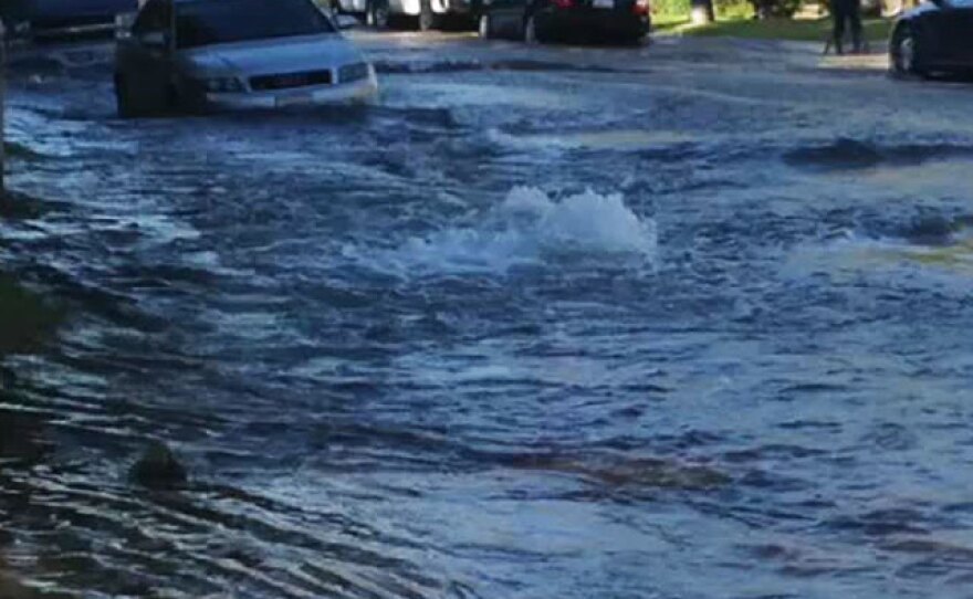 A car is surrounded by water after a water main ruptured in a Birdland-area neighborhood, Sept. 3, 2014.