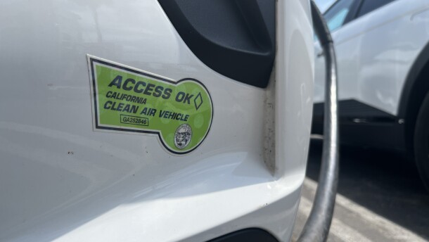 An electric vehicle with a Clean Air Vehicle decal charges at a public lot in Encinitas, Aug. 12, 2025.