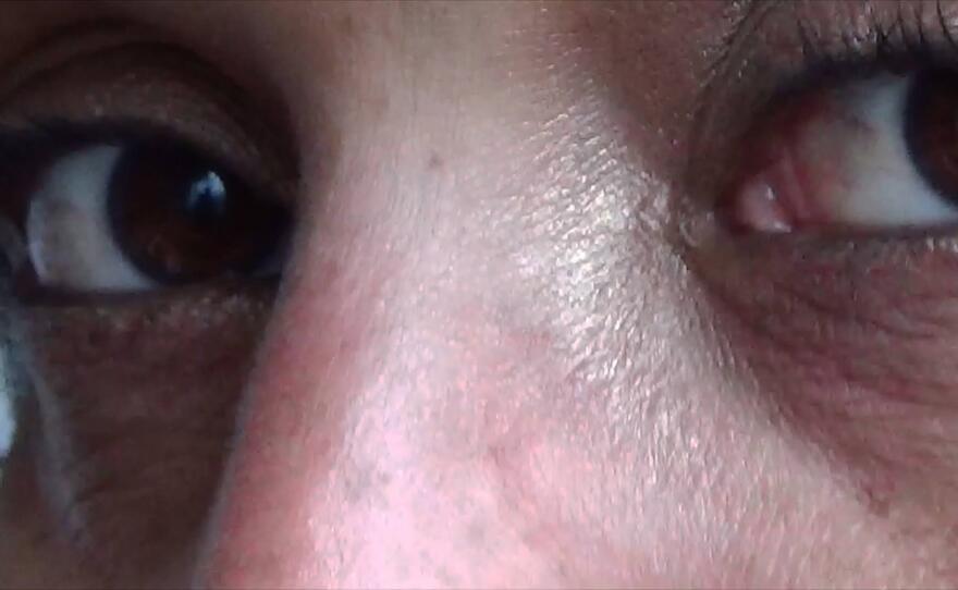 An extreme close-up of Rozana’s brown eyes and lightly freckled skin. She looks to the left of the camera, almost directly at the lens.