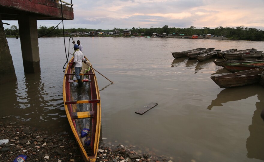 Men in the city of Quibdó prepare the motorboat they use to make the hours-long river journey to a cacao community. Most Chocó farmers live in riverside communities far from Quibdó and must travel there to sell their crops — by motorboat, because the villages lack roads.