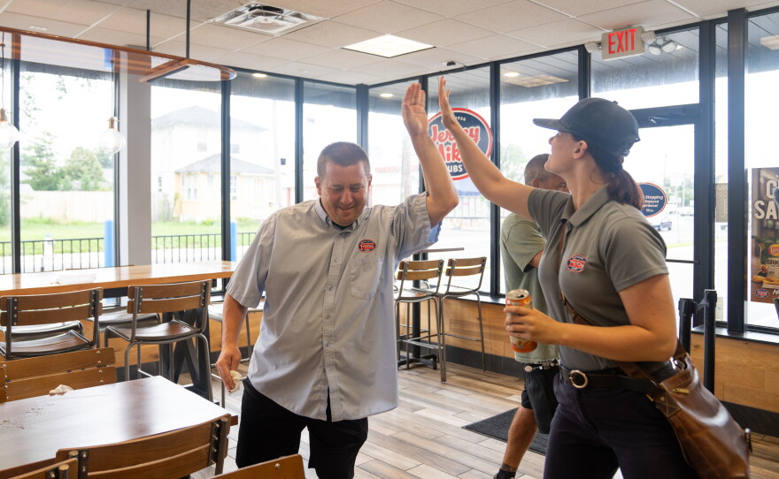 Another Next Steps participant works alongside Cody at Jersey Mike's for job training. Here, he high-fives another employee as they start their shifts at the sub shop.