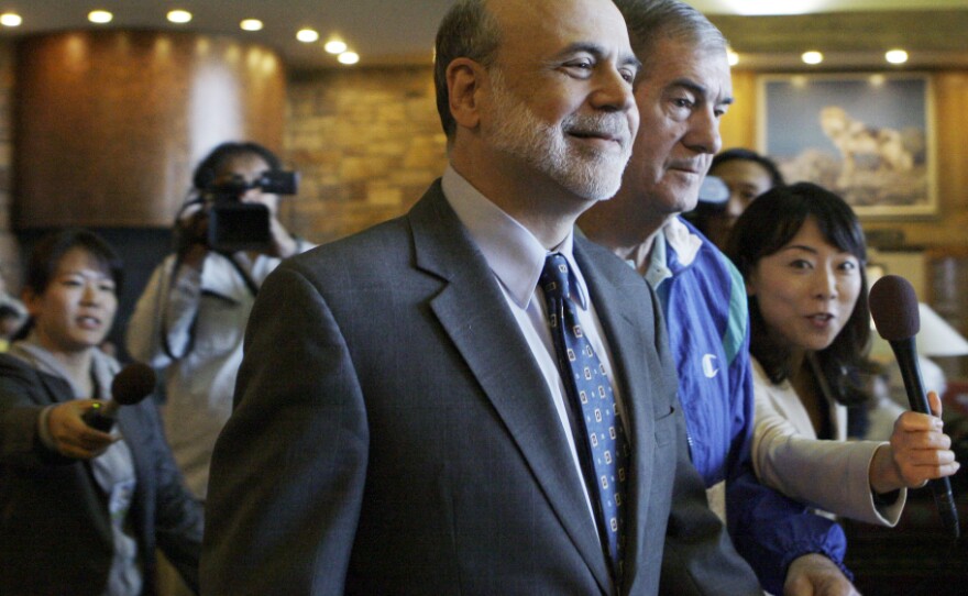Federal Reserve Chairman Ben Bernanke walks past reporters as he arrives at the economic policy symposium at Jackson Hole in Moran, Wyo., on Friday.