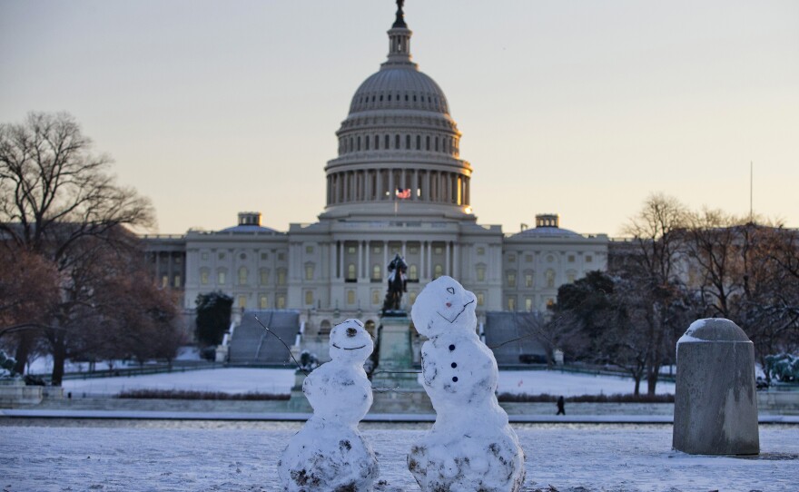 Snowmen sit in front of the Capitol in Washington, D.C. Roads are being cleared and many schools systems are closed after a storm blew through the region overnight.