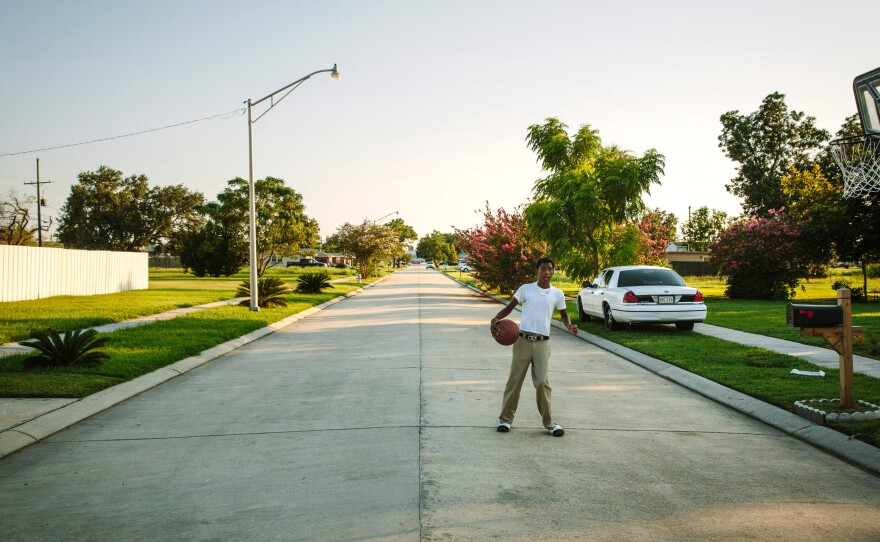 Ronnie Landry, 14, plays basketball in front of his home on Schnell Drive. He and his father, Wilbert Landry, bottom right, moved here from the 9th Ward of New Orleans in 2014. Noney Deffes, bottom left, is a longtime Schnell Drive resident who survived the flood in a neighbor's attic, then lived out of her recreational vehicle before returning to her home.