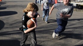 Kids playing a game of touch football in the parking lot of Lincoln Financial Field before the start of an NFL football game between the Philadelphia Eagles and the Denver Broncos Sunday, Dec. 27, 2009, in Philadelphia.