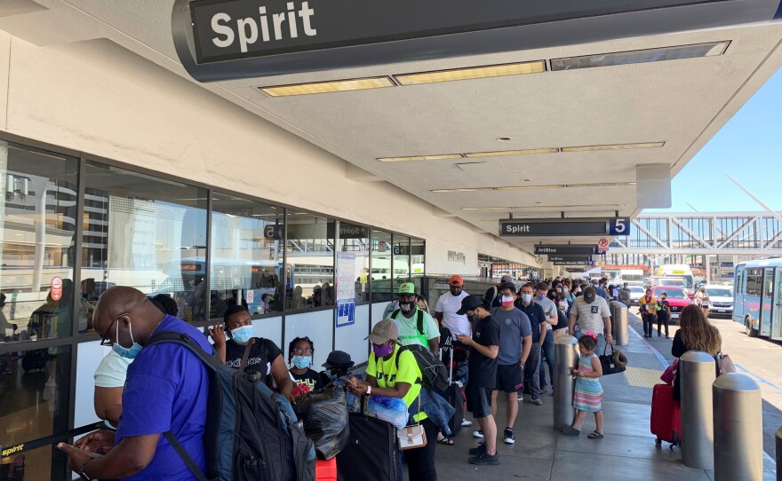 Passengers line up outside the Spirit Airlines terminal at Los Angeles International Airport in Los Angeles on Tuesday, Aug. 3. Spirit Airlines canceled more than half its schedule Tuesday, and American Airlines struggled to recover from weekend storms at its Texas home, stranding thousands of passengers at the height of the summer travel season.