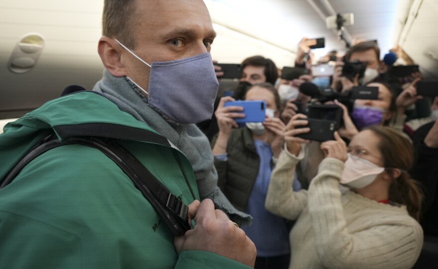 Navalny is surrounded by journalists inside the plane as he walks to his seat on Jan. 17, 2021.