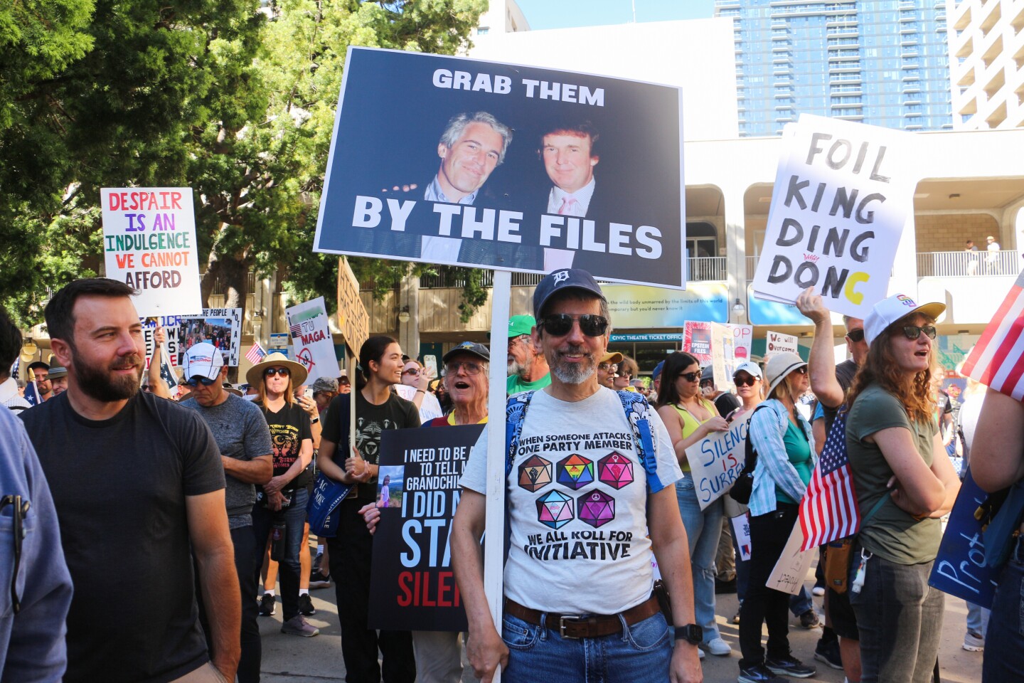 Protestor Joe Borrello holds up a sign that says "Grab them by the files" during a "No Kings" protest on Oct. 18, 2025.