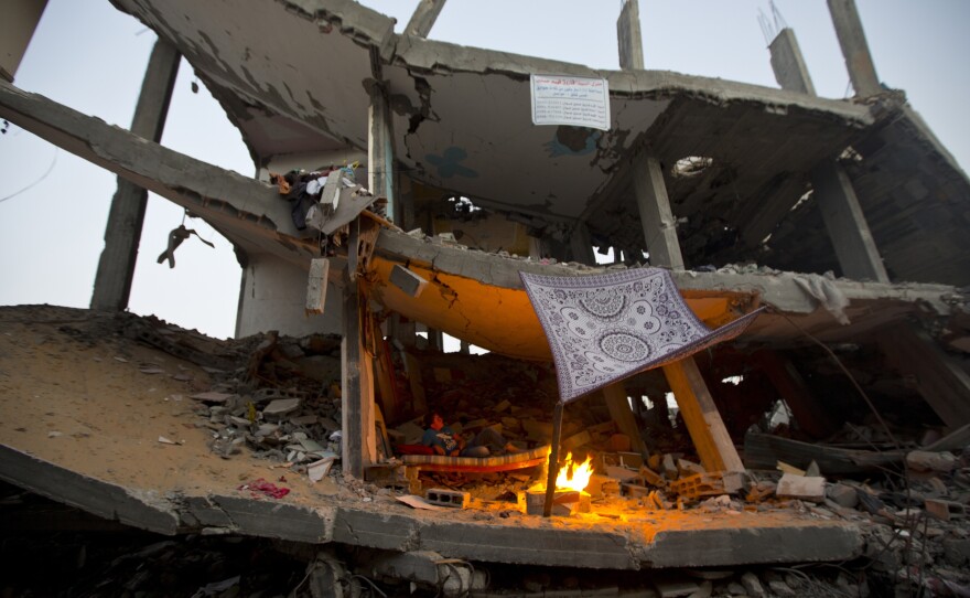 A Palestinian boy sits inside the ruins of his home, which was destroyed in the conflict with Israel, in the Shejaiya neighborhood of Gaza City, in September.