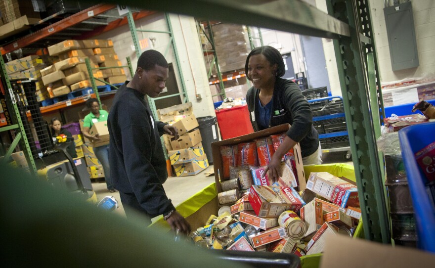 TD Bank volunteers sort donated food into barrels at the Manna Food Center in Gaithersburg in Montgomery County, Md. Poverty in the county, just outside of Washington, D.C., has grown by two-thirds since 2007.