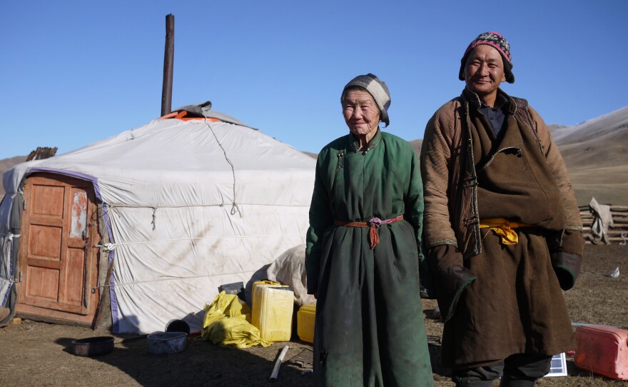 Nomadic herders Lkhagvajav Bish, 90, and her son, Tsahiur Rentsenkhorloo, stand outside their ger in northeastern Mongolia. "All I can do is watch my grassland disappear," says Bish.